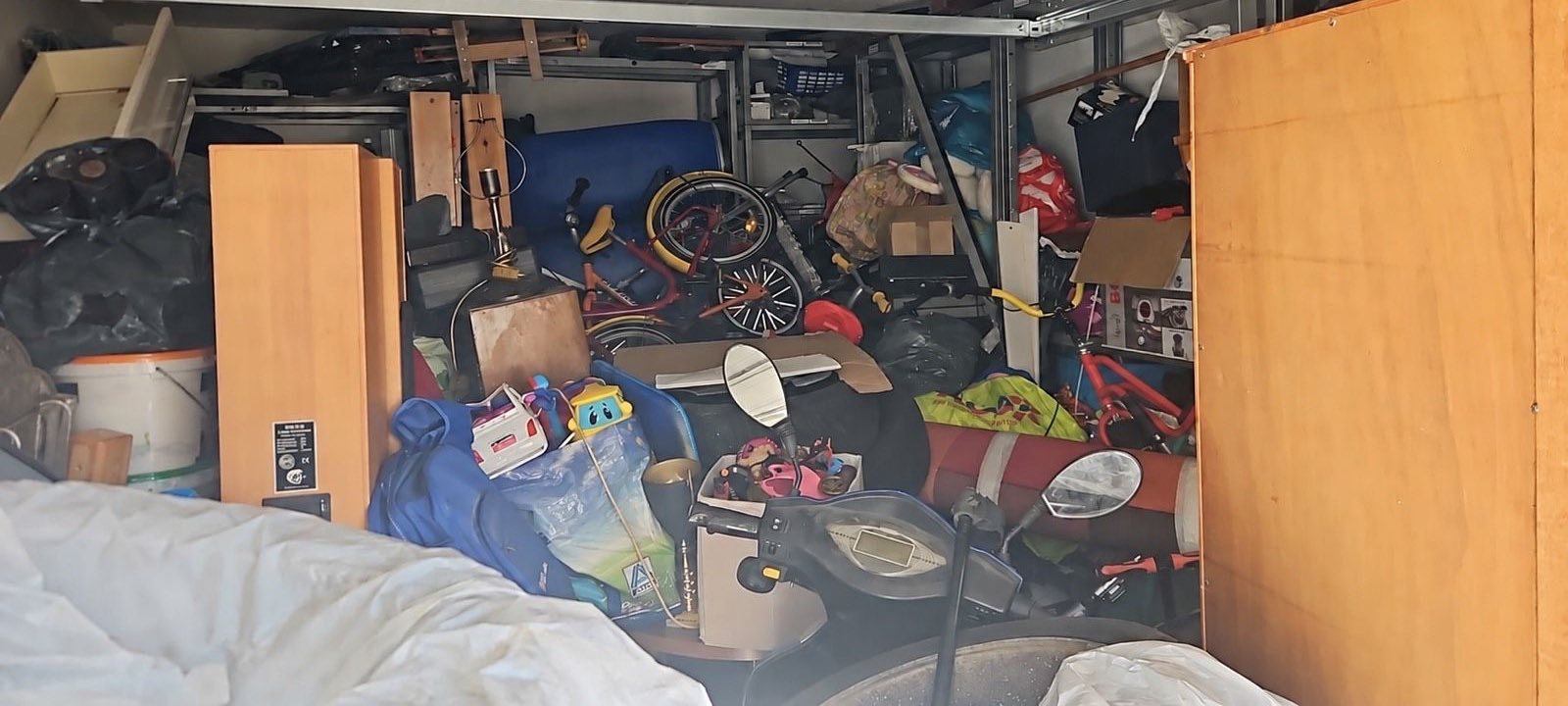 Vorher: Garage bis unter die Decke vollgestellt mit Möbeln, Fahrrädern und Kartons